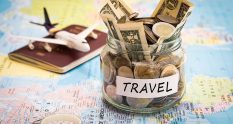 travel savings jar on a world map with passport and model airplane